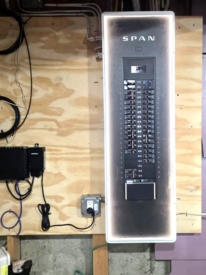 A SPAN smart electrical panel installed by Powered Up LLC, backlit and open to show the breaker layout